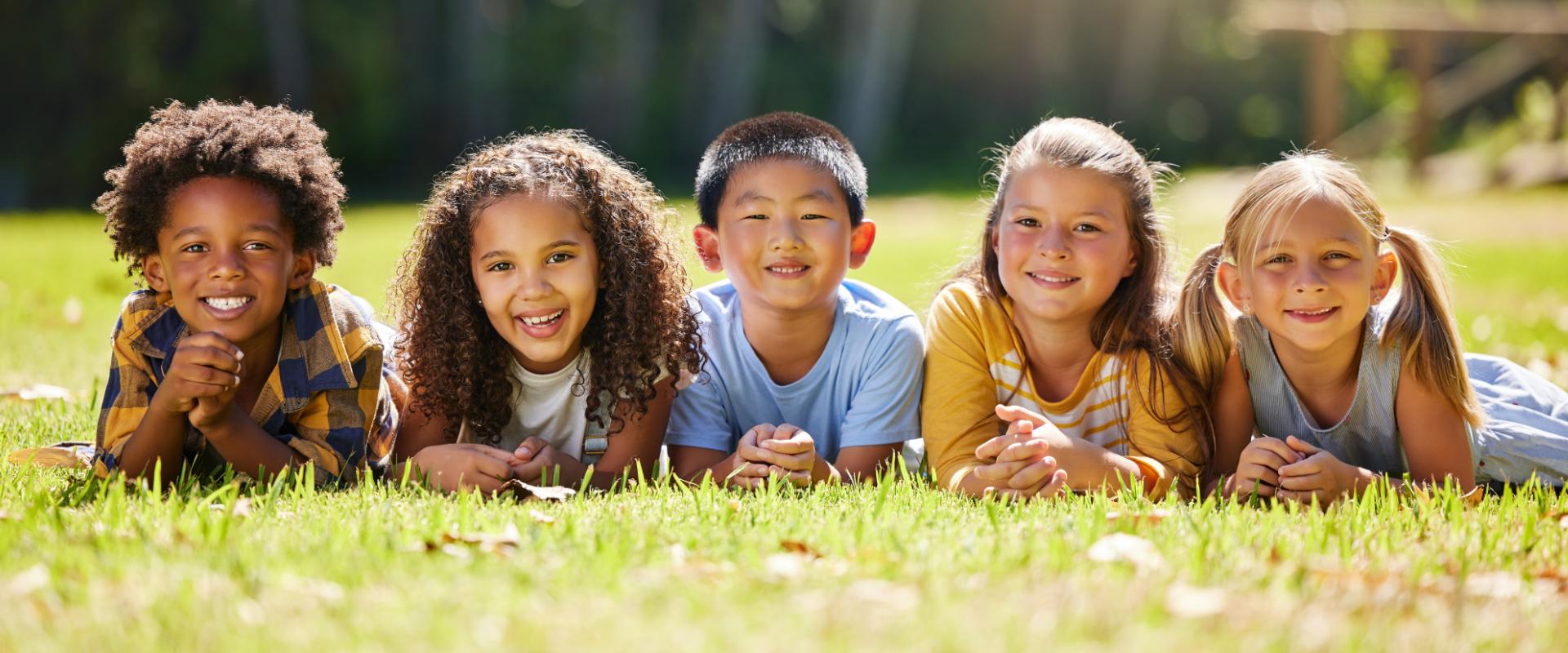 Children laying in grass.